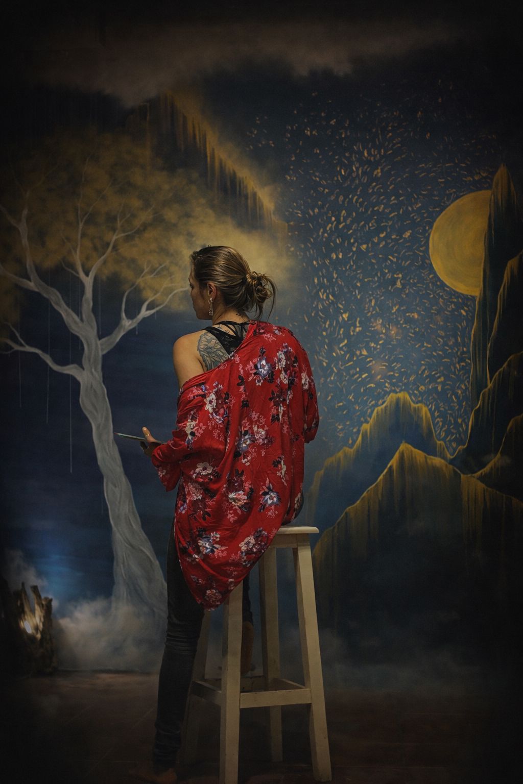 Ächa, Verónica Garrido Fernández, pintando un mural nocturno con un árbol dorado y una luna llena
